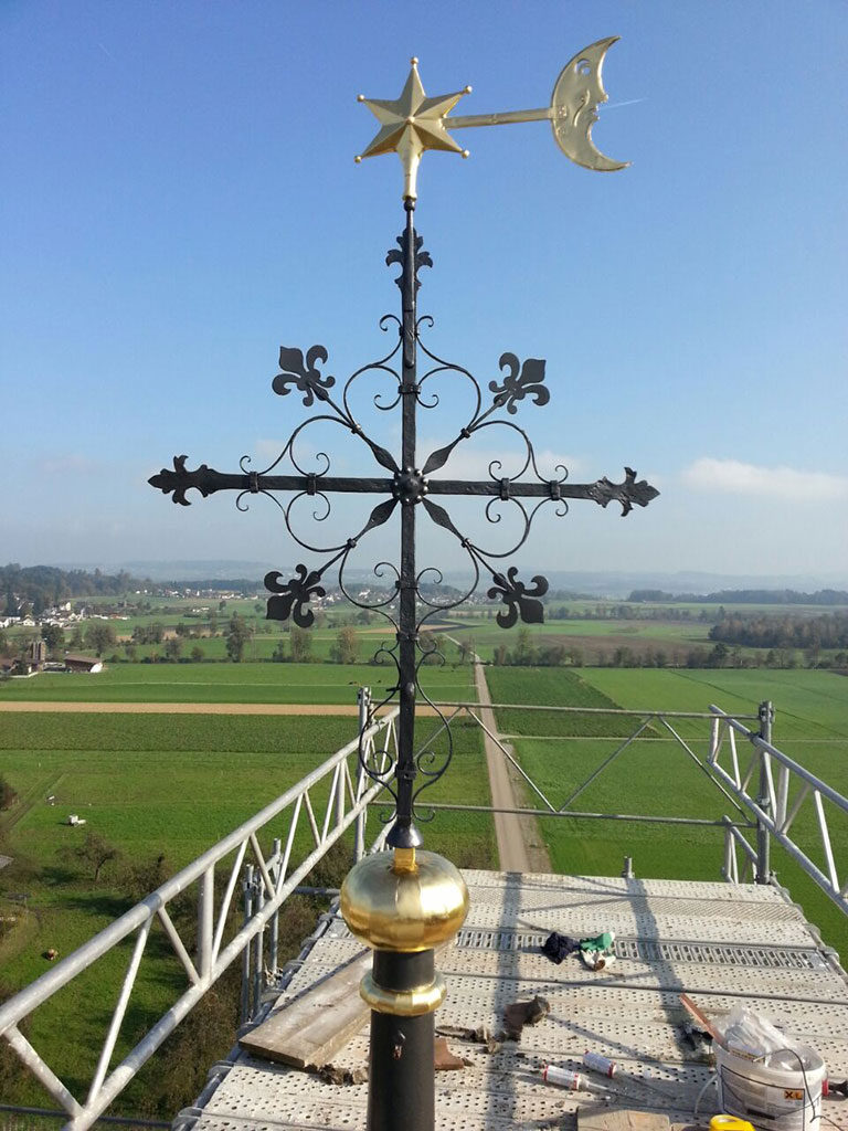 restauriertes Turmkreuz mit blattvergoldeter Kugel und Windfahne